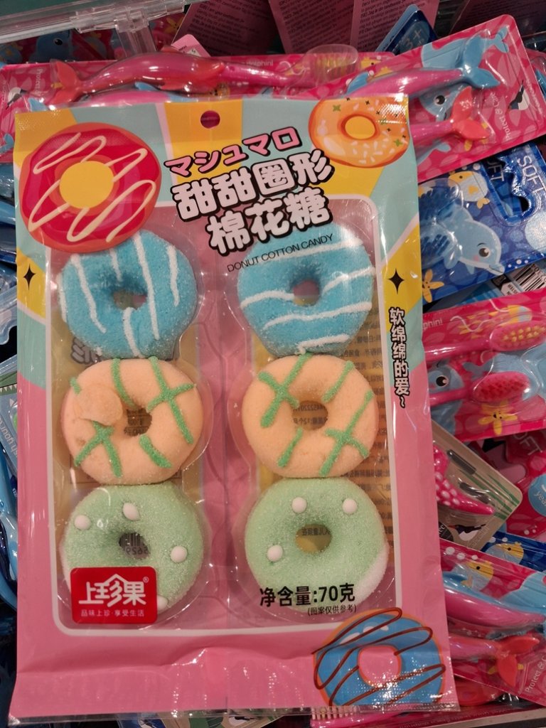 Fargerik plastpakke med kinesisk skrift og seks sukkerdekkede marshmallows i tre ulike farger.