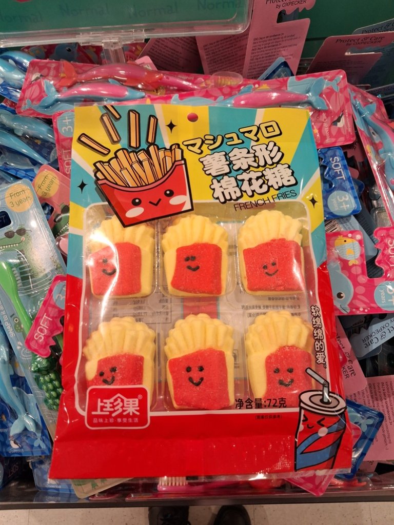 Fargerik plastpakning med kinesisk skrift og seks marsmallows i form av french fries.