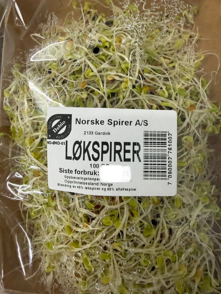 En pakke løkspirer i avlangt pappebeger med plast rundt.